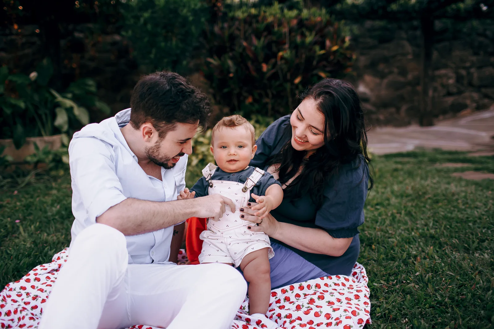 Two parents spending time outdoors with their baby; illustrative stock photo, not identified MM2H applicants.